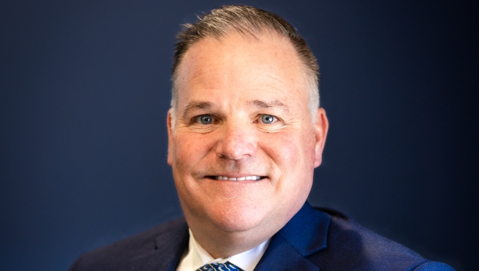 Headshot of middle-aged male banker in suit and tie.