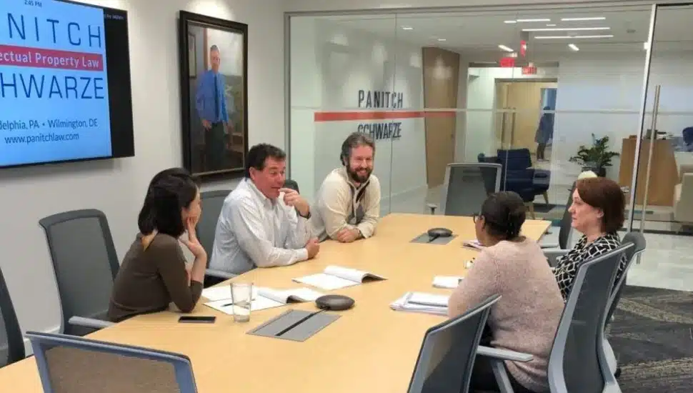 Lawyers talk around table in conference room.