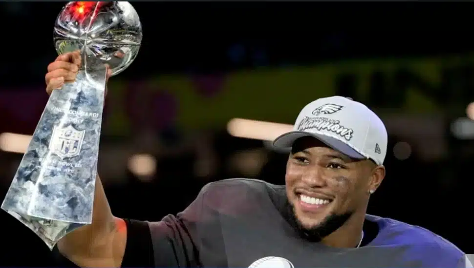 Saquon Barkley holding trophy after Super Bowl win.