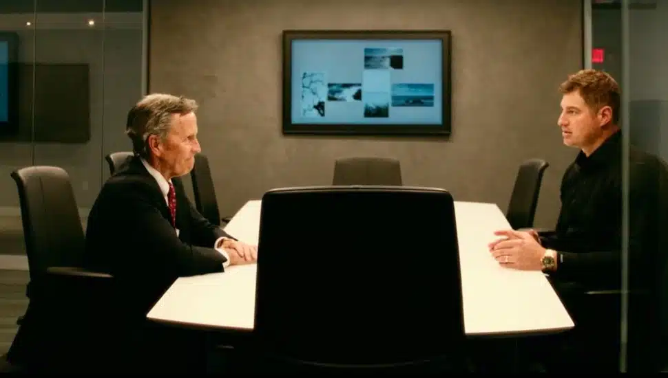 Chris Annas, Chairman, President and CEO of Meridian Bank, sits at a conference room table at Meridian Bank with Brent Celek.
