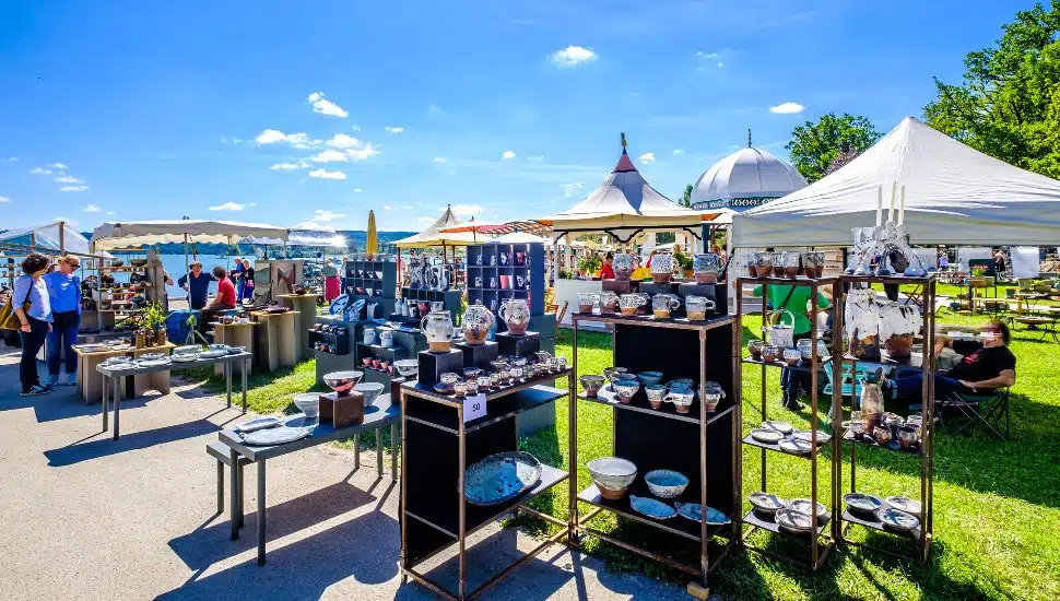 Vendors set up for craft fair on sunny day.