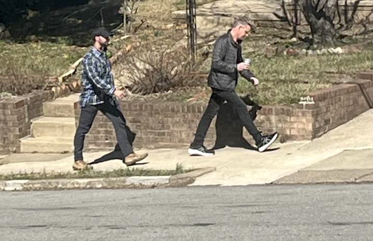 Gordon Ramsay and another person walking down sidewalk.