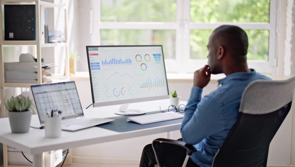 Businessman Using Analytics/Data at computer to analyze trends.