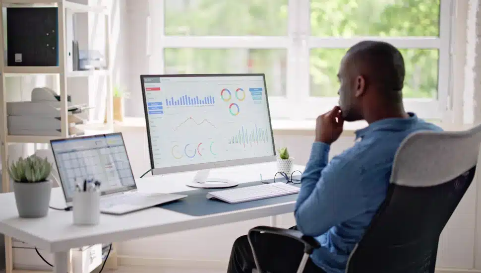 Businessman Using Analytics/Data at computer to analyze trends.