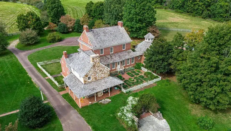 Side aerial view of brick house and large land space at 110 Frog Hollow Road.
