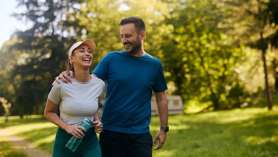 Cheerful couple having fun while exercising in nature.