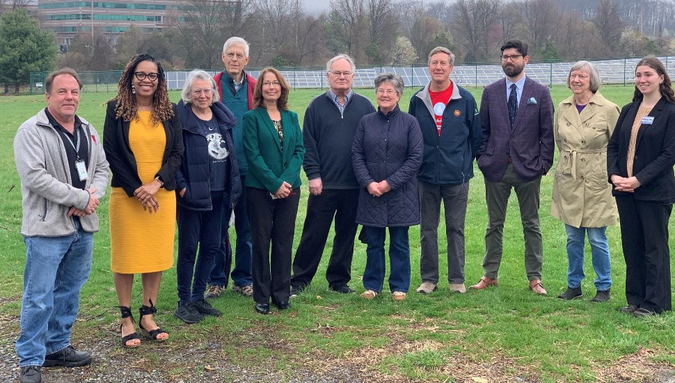 Local officials pose for picture near school's solar energy installation.