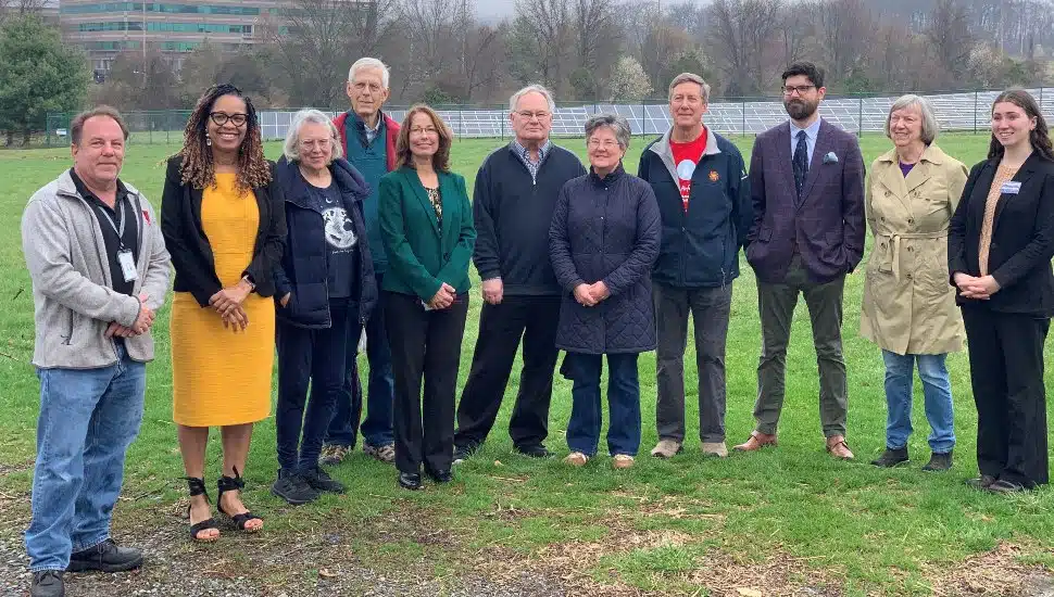 Local officials pose for picture near school's solar energy installation.