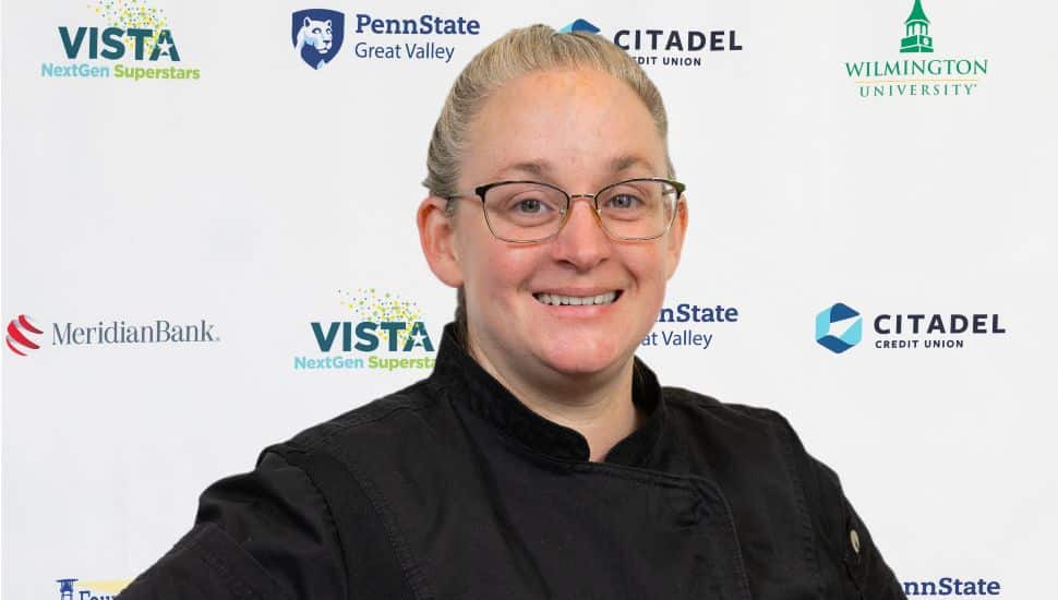 Headshot of Carey Snow: She has light hair pulled back into a pony tail, wears glasses and a black shirt. She is facing the camera and smiling.