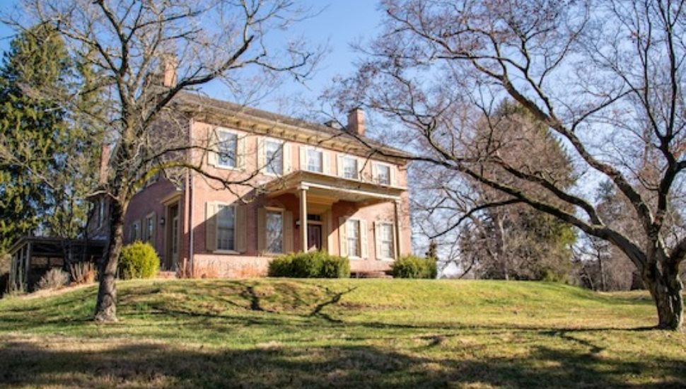 Davis Tract House on hill surrounded by some trees.