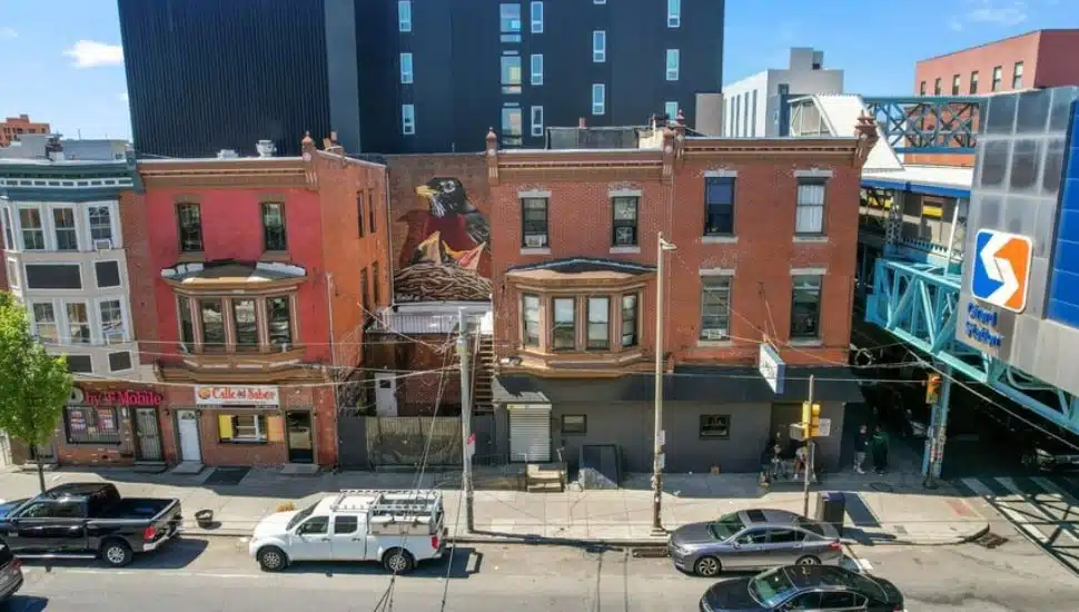 Three brick Fishtown buildings with mural on center wall.