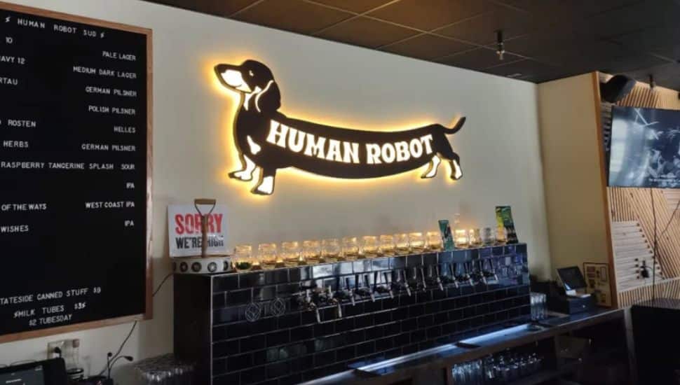 Behind the bar with Human Robot sign on wall in form of a dachshund.