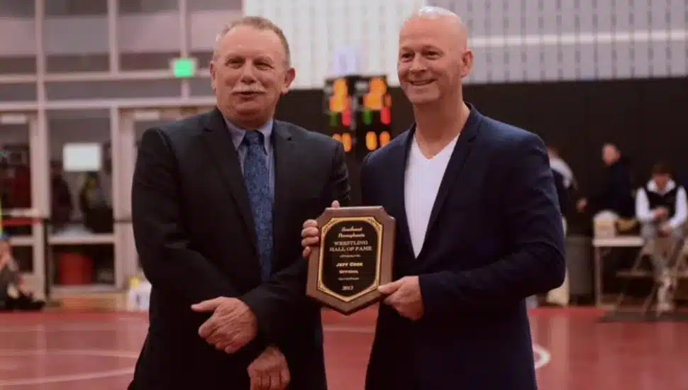 Jeff Cook holding his award standing next to another man.
