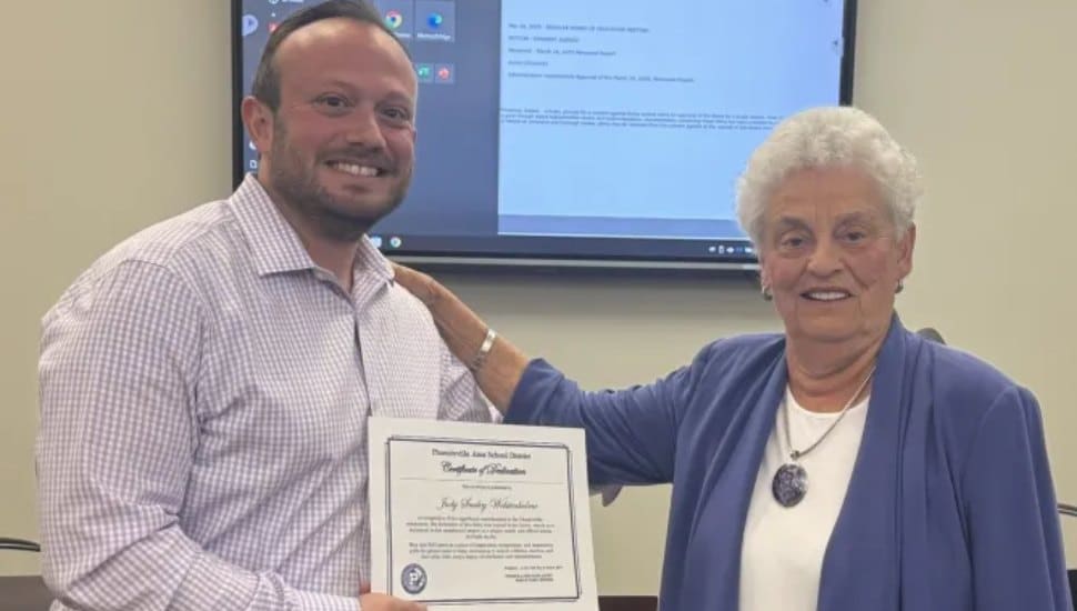 Judy Wolstenholme receiving a certificate from Scott Overland.