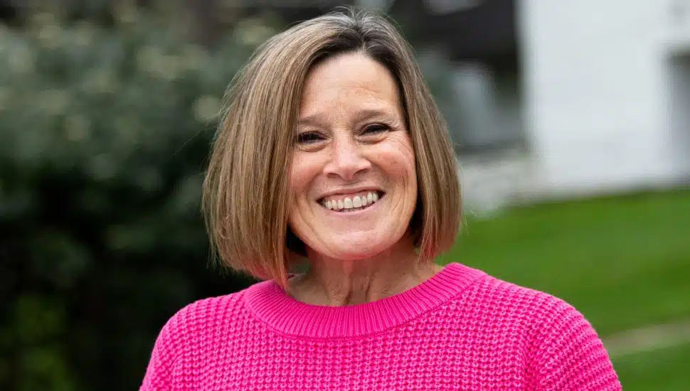 Headshot of woman with brown hair and pink sweater.