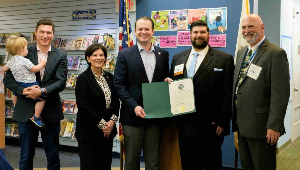 Photo from left to right: Future patron Rory Maxwell with Chester County Commissioner Josh Maxwell, Chester County Commissioner Marian Moskowitz, Chester County Commissioner Eric Roe, Chester County Library System Board President Michael Skay, and Chester County Library System Executive Director Joe Sherwood. Group is gathered at the library holding the proclamation open.
