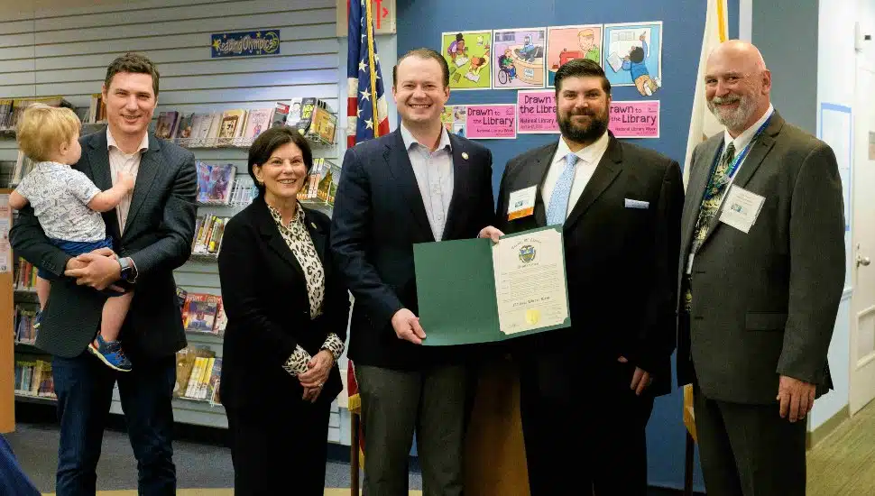 Photo from left to right: Future patron Rory Maxwell with Chester County Commissioner Josh Maxwell, Chester County Commissioner Marian Moskowitz, Chester County Commissioner Eric Roe, Chester County Library System Board President Michael Skay, and Chester County Library System Executive Director Joe Sherwood. Group is gathered at the library holding the proclamation open.