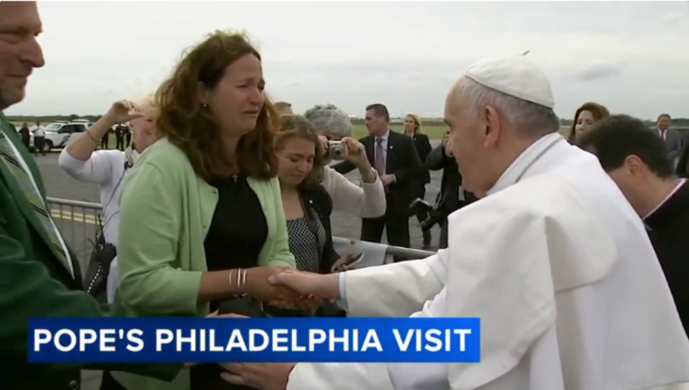 In a crowd of people, Pope Francis Shakes Kristin Keating's hand.