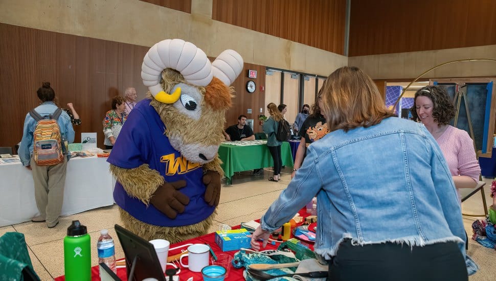 Rammy, the WCU mascot, gathers at a table at WCU’s Annual Zero Waste Summit.