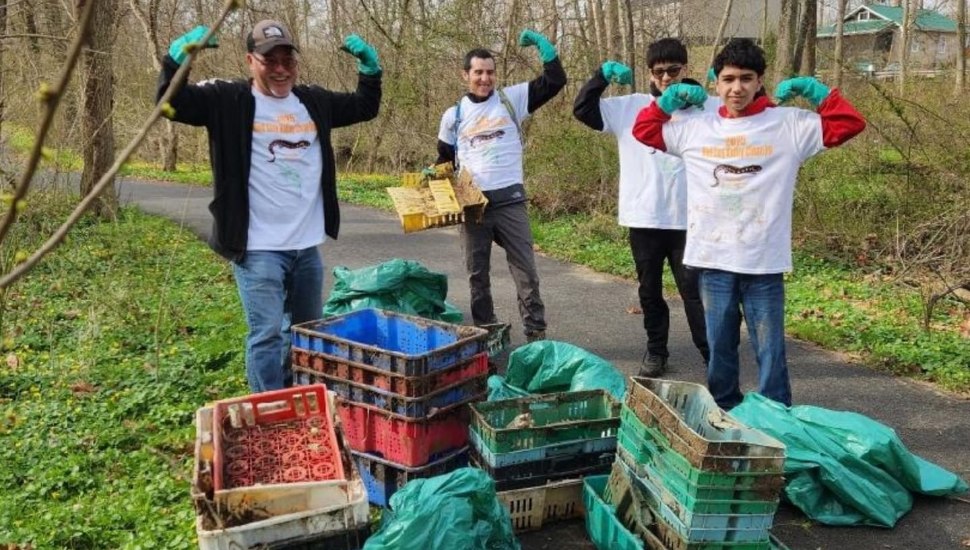 Red Clay Creek cleanup volunteers posing with pile of trash they cleaned.