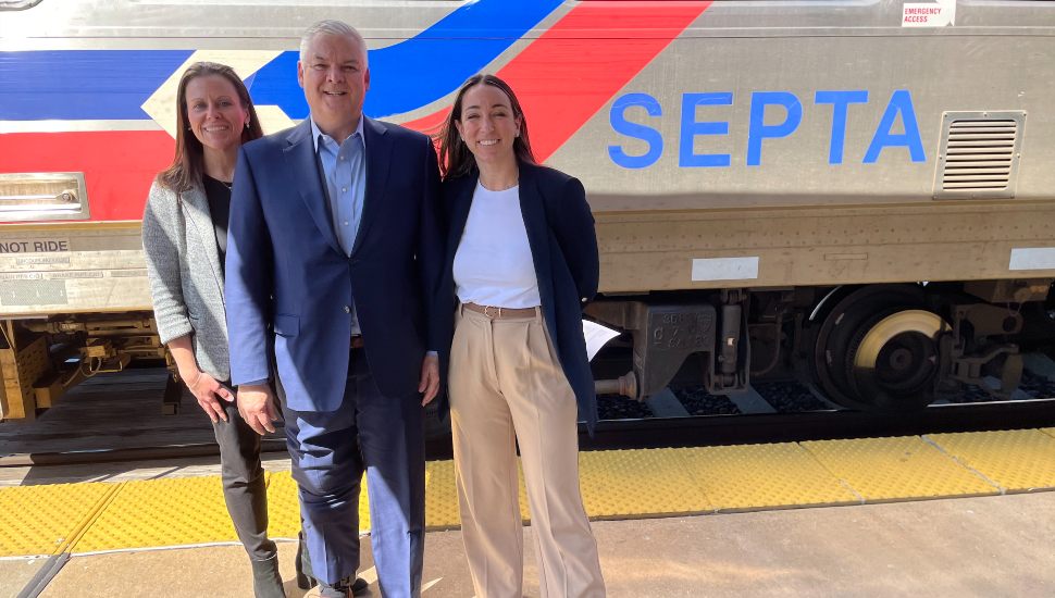 From right, Trish McFarland, Bernard Dagenais, and Laura Manion stand with a SEPTA train behind them.