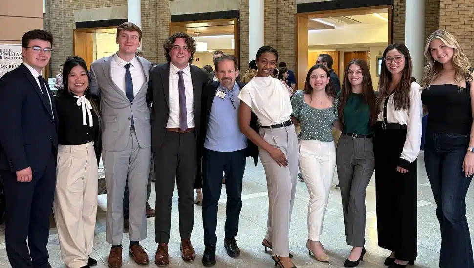 WCU students and WCU’s Cottrell Center’s Entrepreneur-in-Residence Marc Duey at Wistar Institute's Life Science Innovation Shark Tank competition. The student are gathered in a line with arms around each other. They are dressed in professional attire.