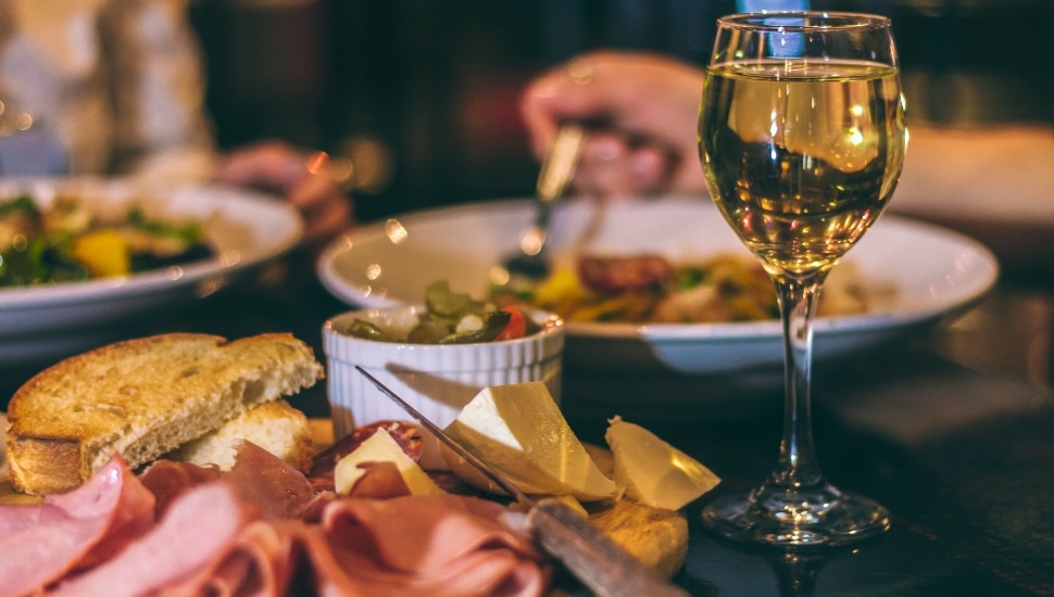 Itailian meal at dinner table with wine and plates.