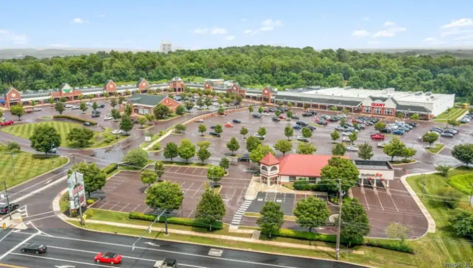 Suburbia Shopping Center aerial view with lots of parking and trees.