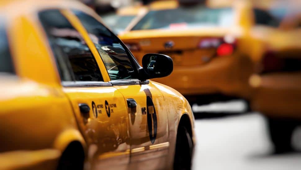 Yellow taxis driving on busy street.