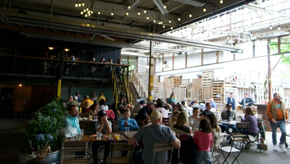 People sitting at tables with string lights hanging at The Creamery of Kennett Square.