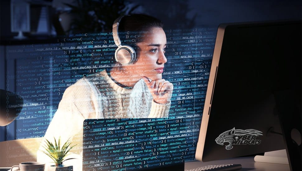 The image features a woman sitting at a desk, focused on a computer screen displaying streams of green and white code. The room is dimly lit, with the glow from the screen illuminating her face, highlighting her concentration.