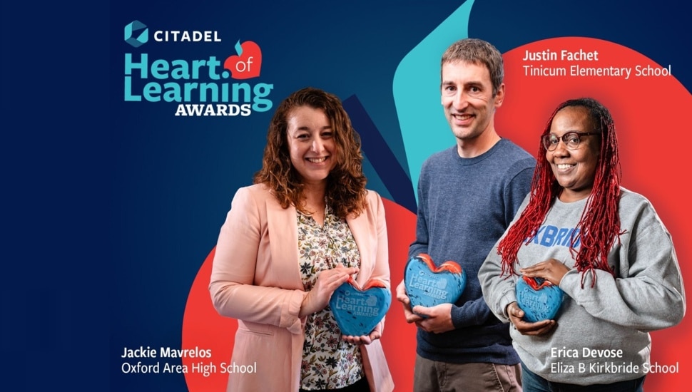 Three teachers hold awards with bank signage in background.