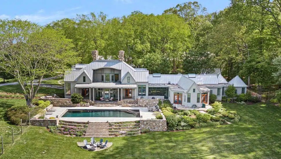 2299 Hilltop View Road with pool in yard of green grass and trees.
