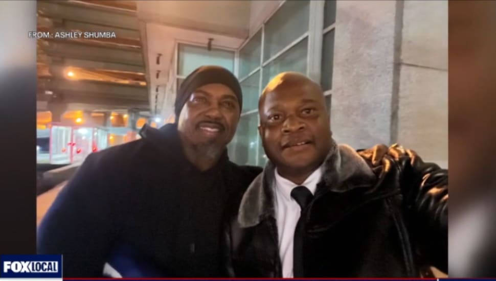 Two African-American men embrace and pose for a picture.