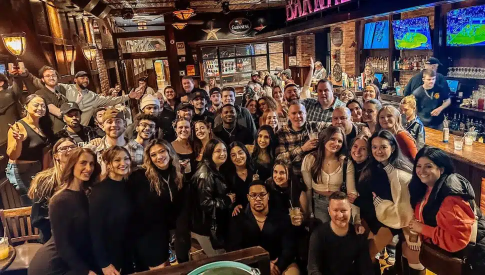 A crowd of people all smiling for a photo at Barnaby's sports bar in West Chester.