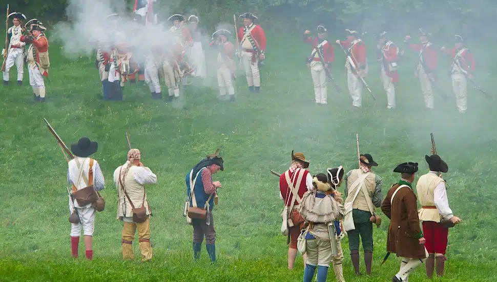 Revolutionary War-era reenactment on a field.