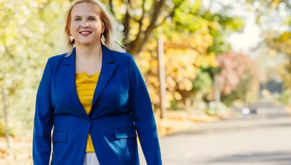 Erica Deuso walks outside wearing blue blazer.