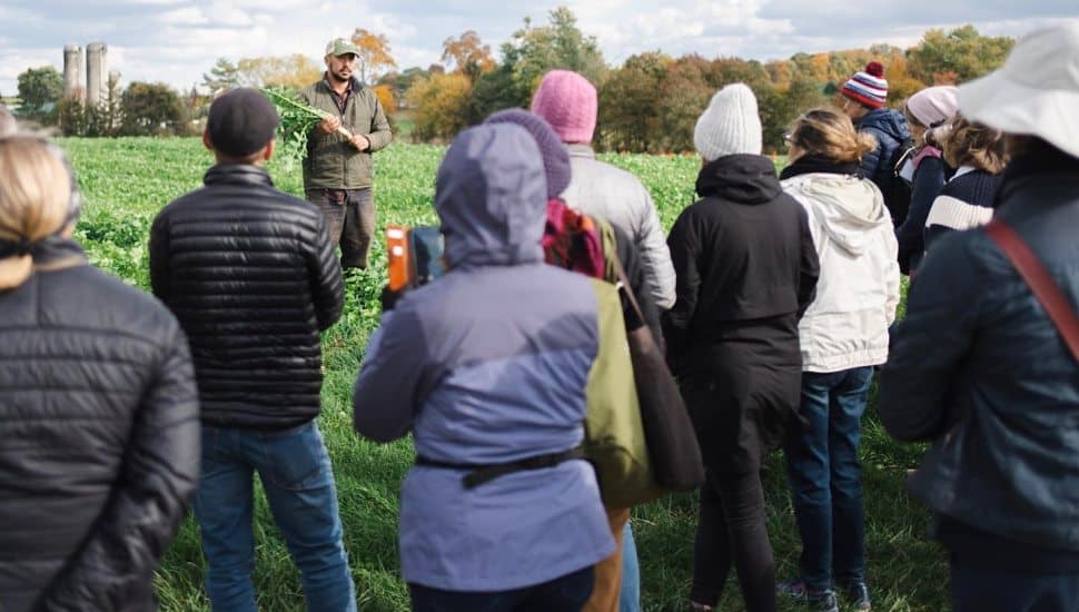 People at FarmerJawn getting educated by farm in field.