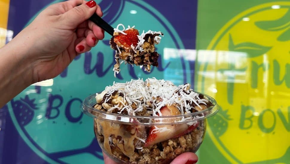 Person scoops spoonful of food from a Frutta Bowls item.