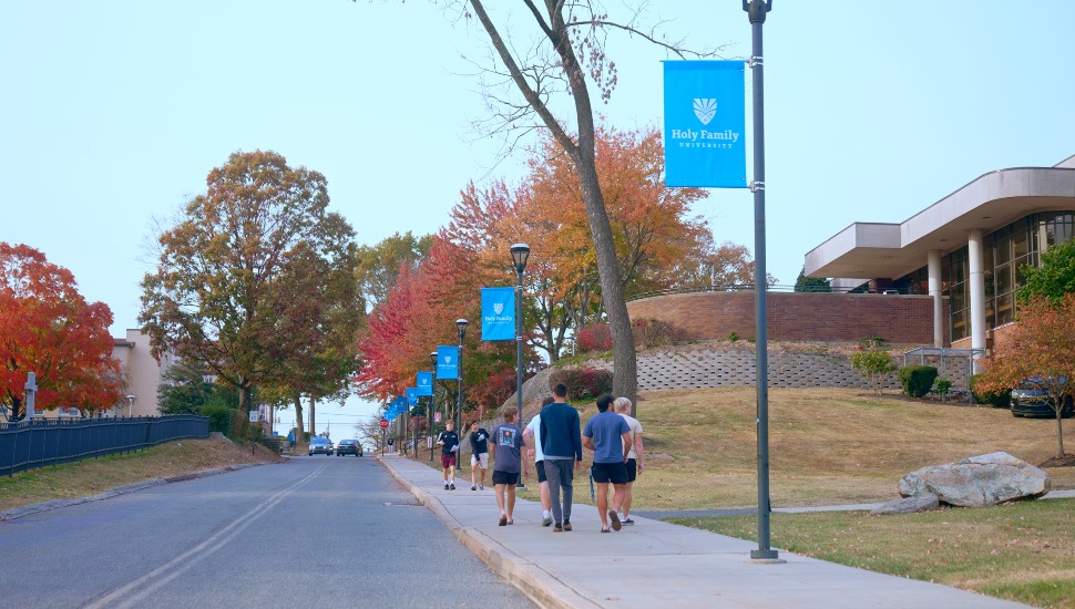 College students walk on campus sidewalk.