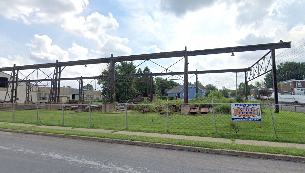 Abandoned lot with fence and grass for sale.