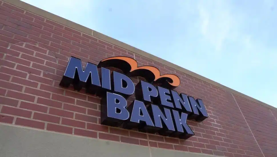 Exterior view of bank signage on red brick wall.