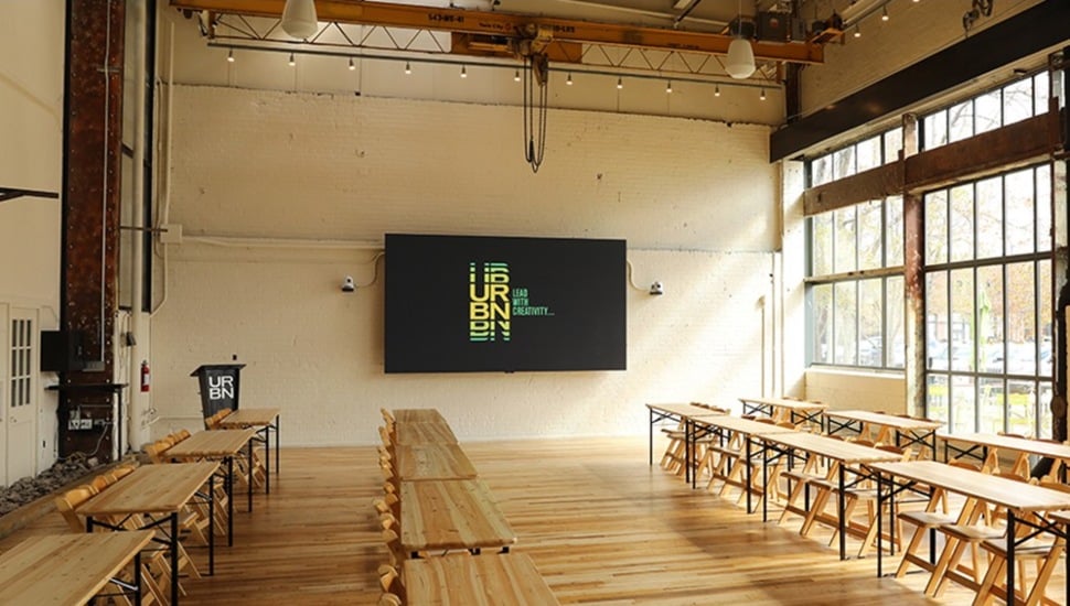 Empty lecture hall in industrial setting with mounted television.