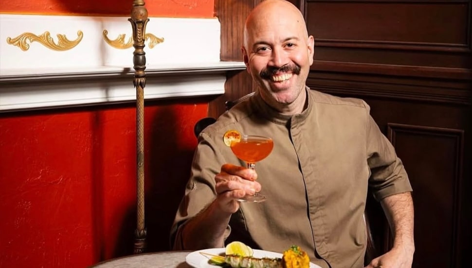 Yun Fuentes smiles at camera holding a drink.