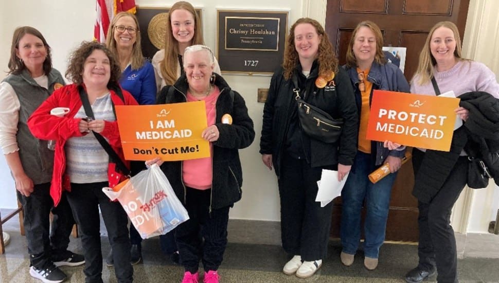 Arc advocates and self-advocates hold signs supporting Medicaid funding meet with staff for Rep. Chrissy Hoolahan