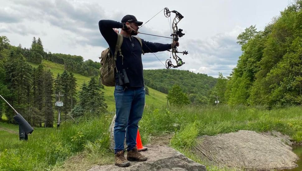 Man holding bow and arrow at Bigshot Archery.