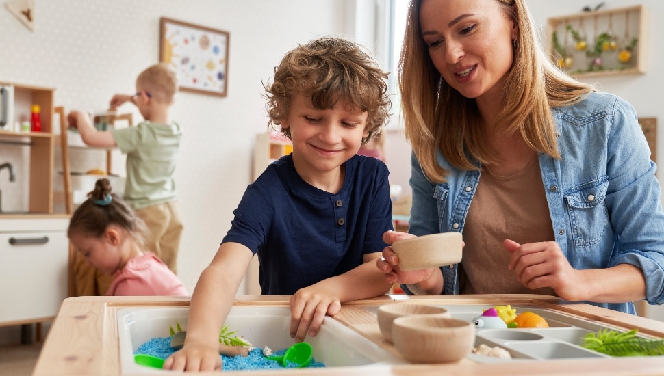 Child Care provider playing with young boy.