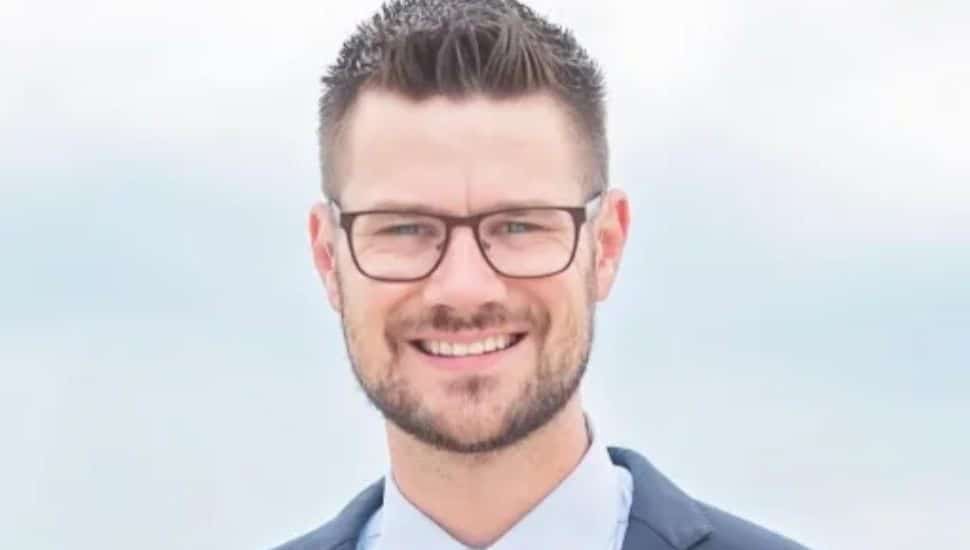 Eden Ratliff headshot with glasses and suit.