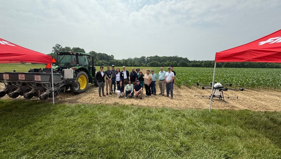 FMC Corporation team stands together in front of cornfield.