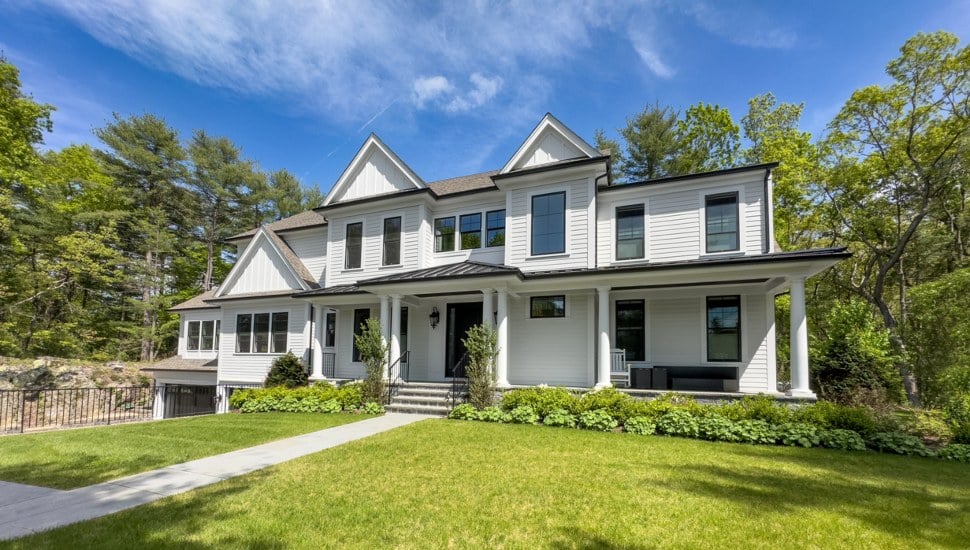 Standard white house with black trim on green lawn.